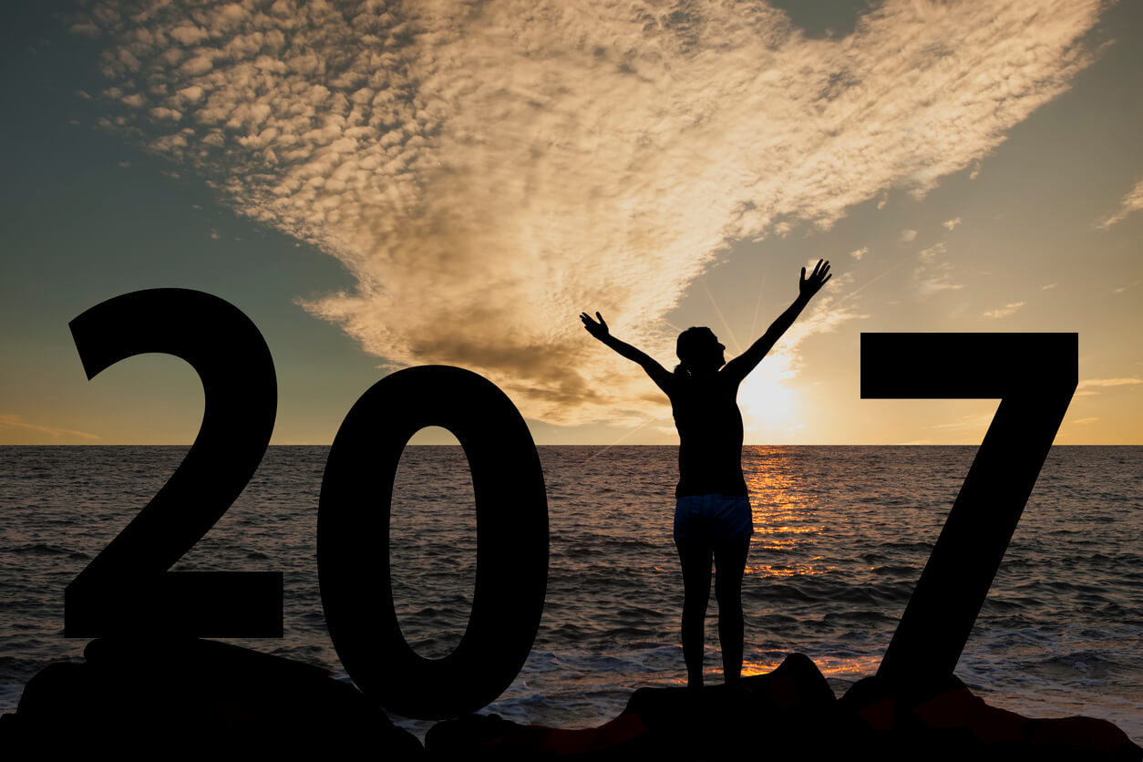 Person silhouette standing in 2017 on the hill at sunset Person silhouette standing in 2017 on the hill at sunset